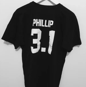  - Svart T-shirt med vitt tryck på ryggen från LPD köpt i Sydney. 
