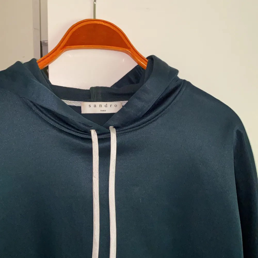 Jättefin hoodie från Sandro med inbyggd skjorta. Tyget är lite glansigt, jättefint! Knappt använd, inköpt för ca 3000kr. . Hoodies.