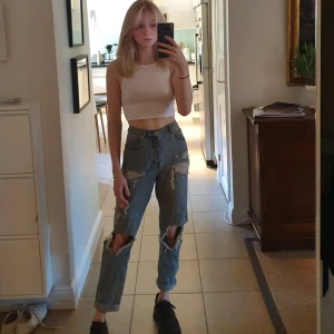 Slitna jeans - Slitna ljusblå momjeans. (Har justerat byxorna så de ska se ut som de gör när de passar. De är alltså för stora för mig egentligen) Frakt tillkommer, kan även mötas upp i Stockholm.