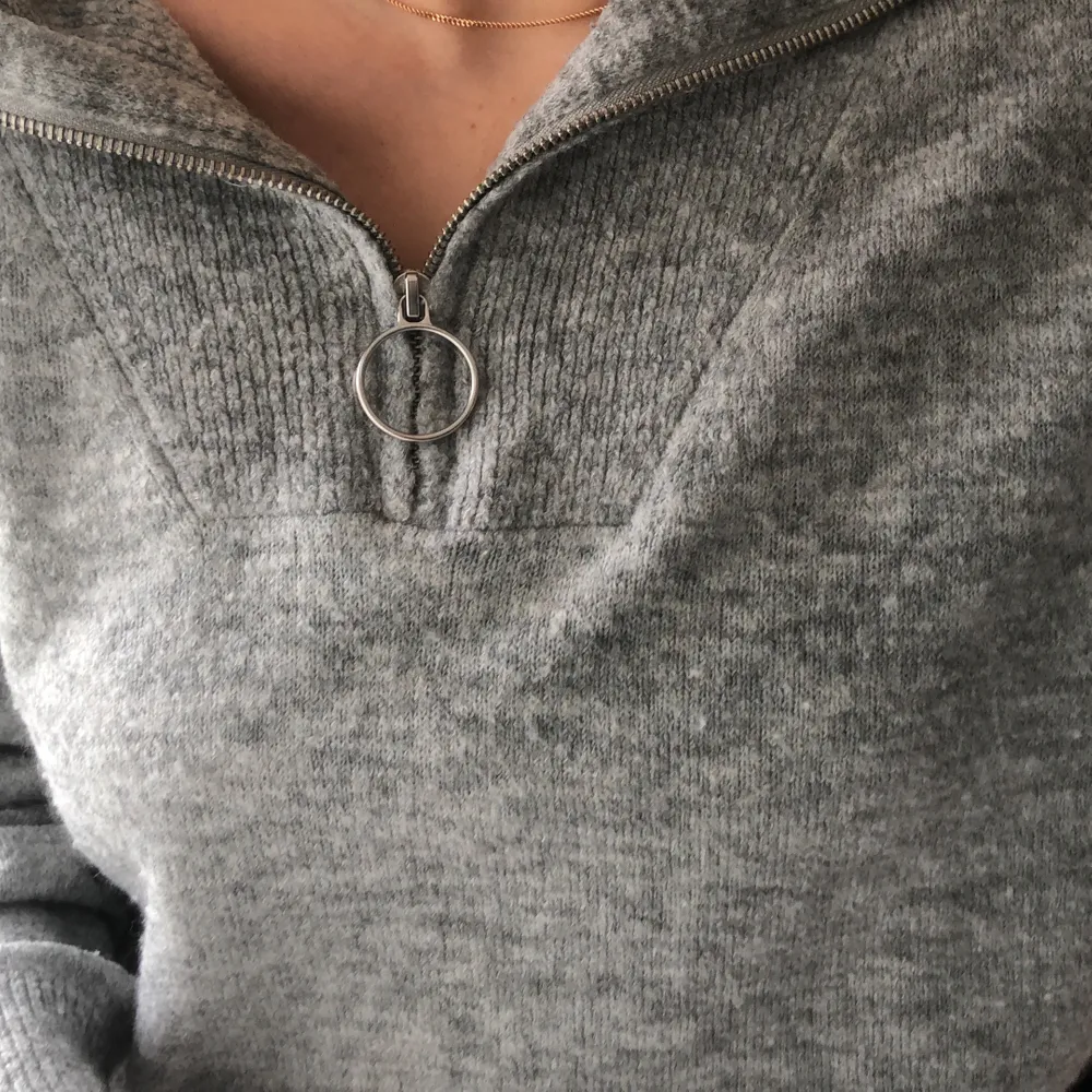 Grå stickadtröja med en zip i kragen från H&M! Sitter tajtare i midjan (se bild 2) och har silver detaljer. Storlek M men passar även S!💫. Stickat.