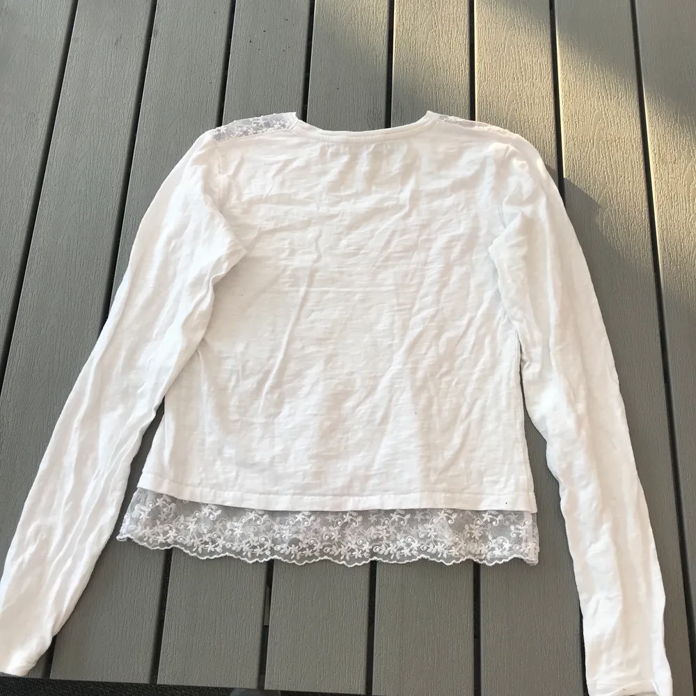 En fin vit tunn långärmad tröja med vit spetts på axlar och i slutet av tröjan. Den är i storlek 158,164 som är ungefär som en XS. Jag har endast använt den någon gång så den är som ny. (Frakten ingår i priset). Toppar.