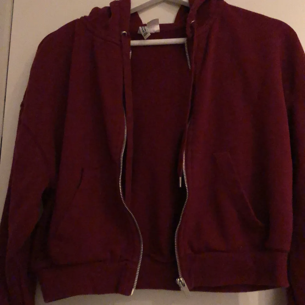 Vinröd hoodie med luva och zipper. Den är croppad. Passar s-m . Hoodies.