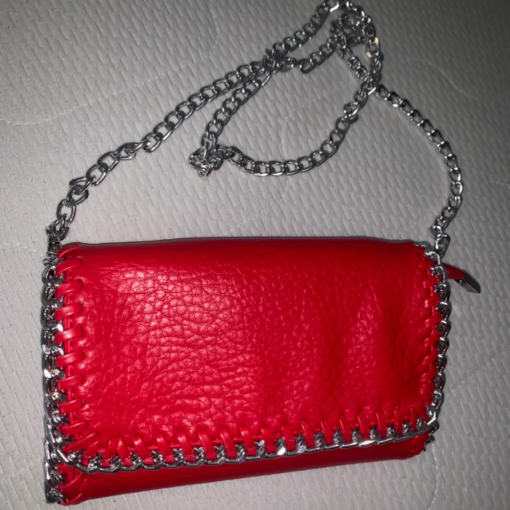 säljer denna underbara väskan från TIAMO i röd med silverdetaljer. Ett av ”banden” inne i väskan har lossnat lite men inget som syns när man bär den! . Väskor.