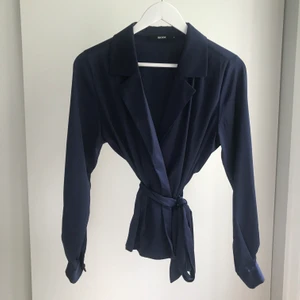 Satintopp  - Mörkblå satintopp. Knytes omlott och med knappar på ärmslutet. Nyskick