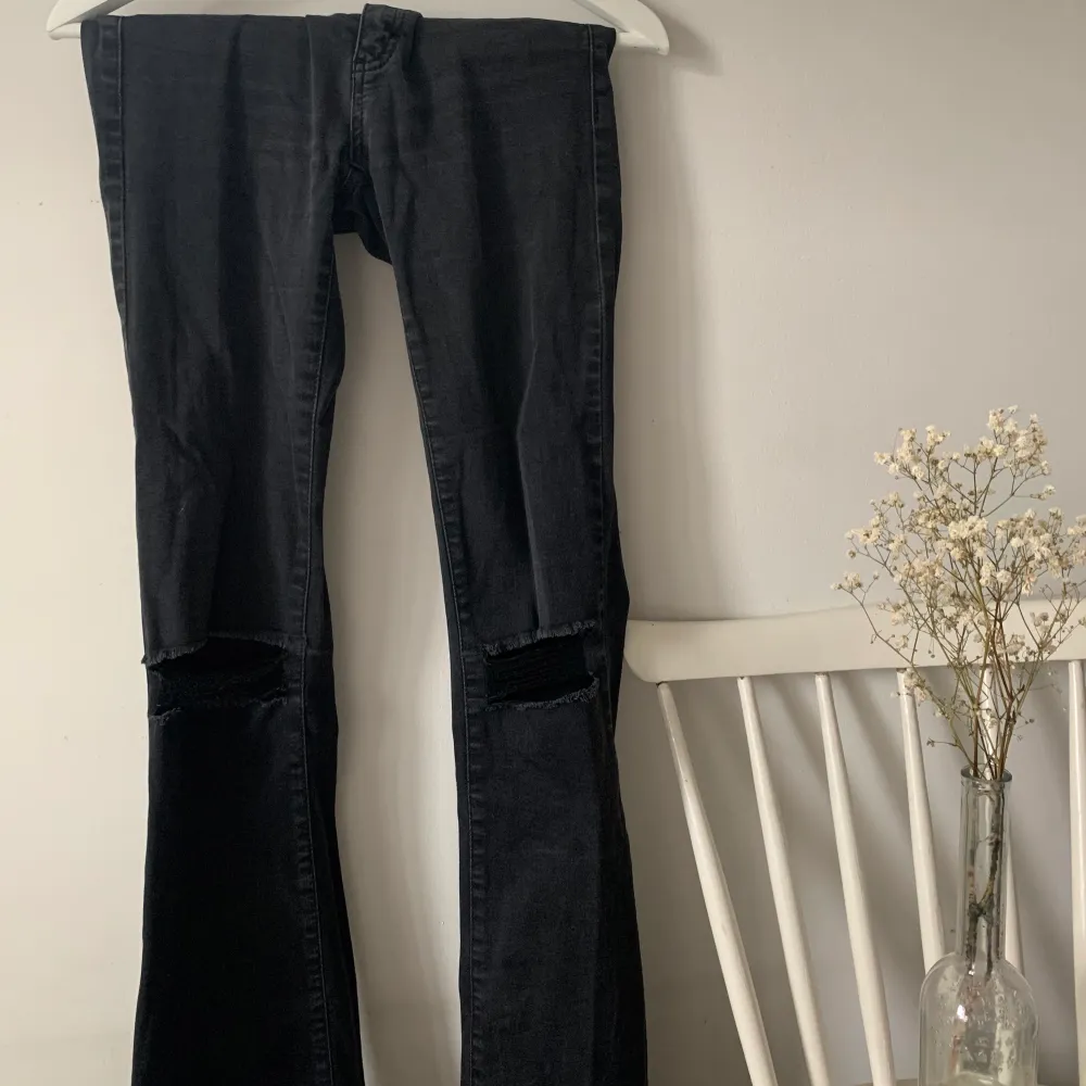 Svarta/mörkgrå tighta bootcut med hål på knäna och lite fransiga längst ner. Slutar strax under naveln. Väldigt stretchiga. Passar en 36-38:a. Frakt ingår ej. Jeans & Byxor.