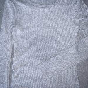 Ljusgrå långärmad tröja från Bikbok i storlek L. Tröjan är tight och rätt liten i storleken men stretchig. Använd några gånger men i bra skick ändå. 