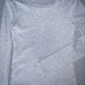 Ljusgrå långärmad tröja från Bikbok i storlek L. Tröjan är tight och rätt liten i storleken men stretchig. Använd några gånger men i bra skick ändå. 