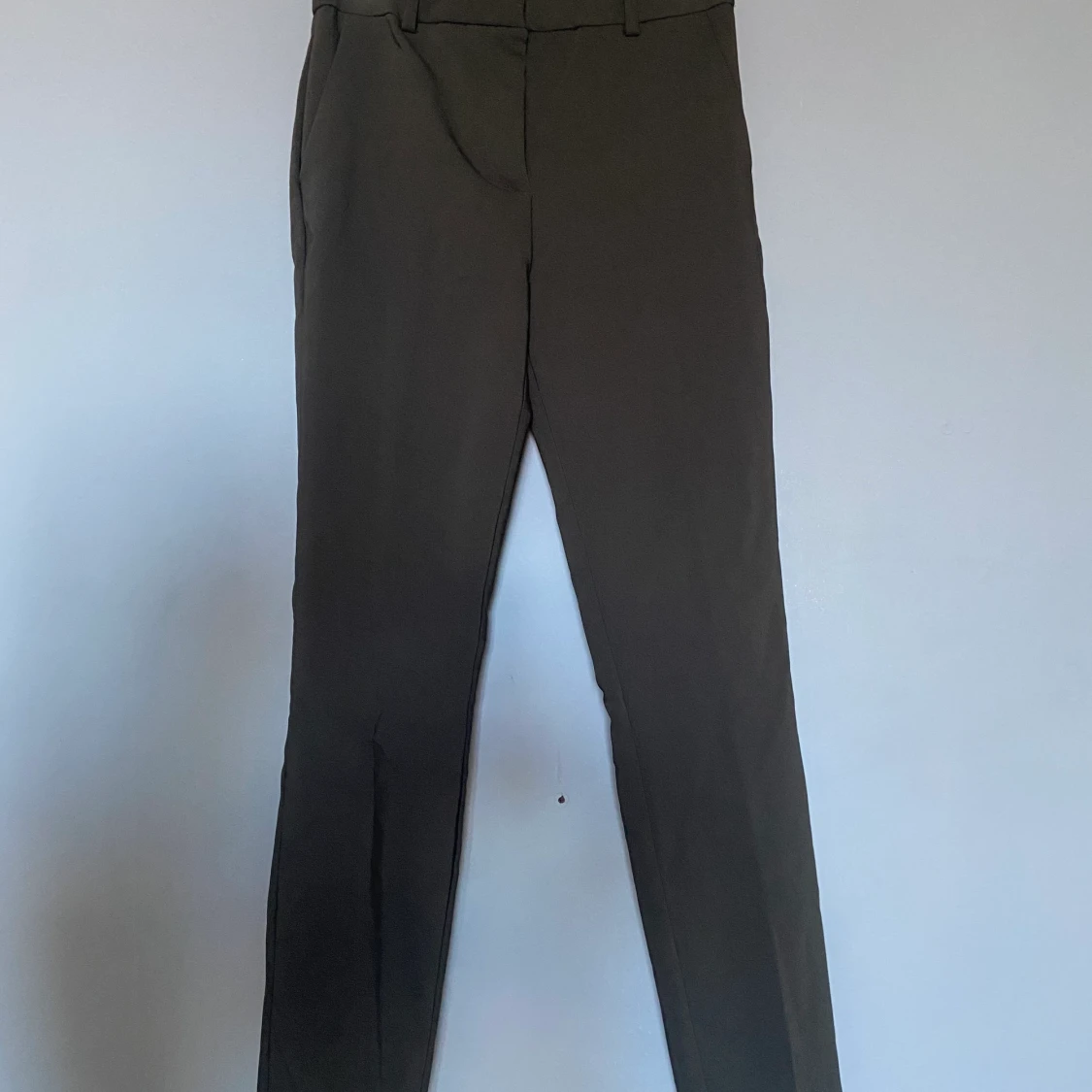 Oanvända mörkgröna kostymbyxor