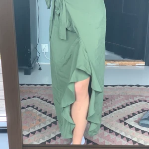 Mörkgrön omlottkjol från NA-KD - Superfin mörkgrön omlottkjol från nakd i strl 36, tyvärr lite stor i midjan för mig som är strl 34. Den fanns i kollektionen AFJ men säljs inte längre❤️ nästan aldrig använd så ja säljer för 150 + frakt❤️ perfekt nu till att det börjar bli varmare!