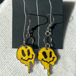 Smält smiley örhängen  - Smältande smileys gula/svarta örhängen, svart baksida, i krympplast. Använda för fotto😳 sanerade efter ofc😉 frakt är 11kr ••••••••••••••••••••••.  (priset höjt pga workload de som skrivit innan 7de får org priset på 50)