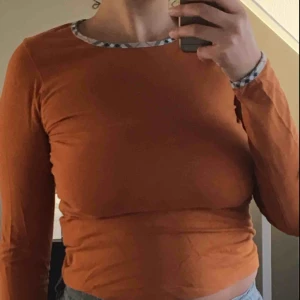  - Äkta burberry långärmad tröja i lite bränd orange färg. Jättefint skick, knappt använd. Sitter tajt på en m och lite looser på en s. 