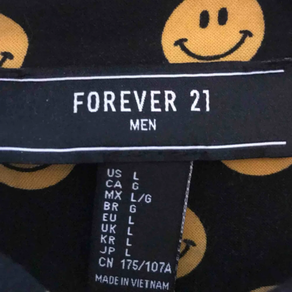 Smileyskjorta från Forever 21 med ficka på vänstra bröstet! Fint skick, köpt i USA!. Skjortor.