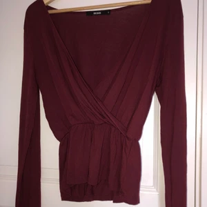 Omlotttopp från Bikbok stl S  - Vinröd, hyfsat kort tröja/topp från Bikbok. Former midjan väldigt snyggt med resår plus en fin urringning. I bra skick använd Max 5 gånger! 