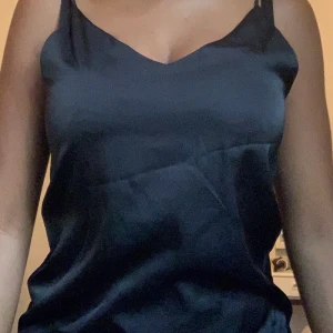 Svart linne  - Säljer detta svarta linne med knappar i bak!