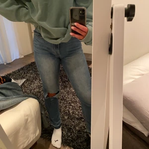 Slitna ljusa jeans - Snygga jeans från hm med hål på ett knä och detalj vid anklarna. Använda en gång