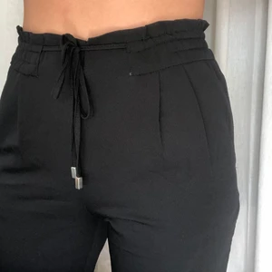 Kostymbyxor fr. Zara strl. S - Svarta kostymbyxor i lite slappare stil från Zara. Knyte runt midjan så går att anpassa passformen, fickor på sidan vilket är +. Inte vida nedtill utan mer raka. Knappt använda så inte alls slitna! Frakt tillkommer om det inte är möjligt att mötas i Jönköping🥰