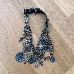  - Sjukt snygg berlockkedja i metall och skinn som man kan använda som  armband och halsband.   Hämtas i Skogås/T-Centralen eller fraktas mot kostnad (köparen betalar). Använd fåtal gånger. 