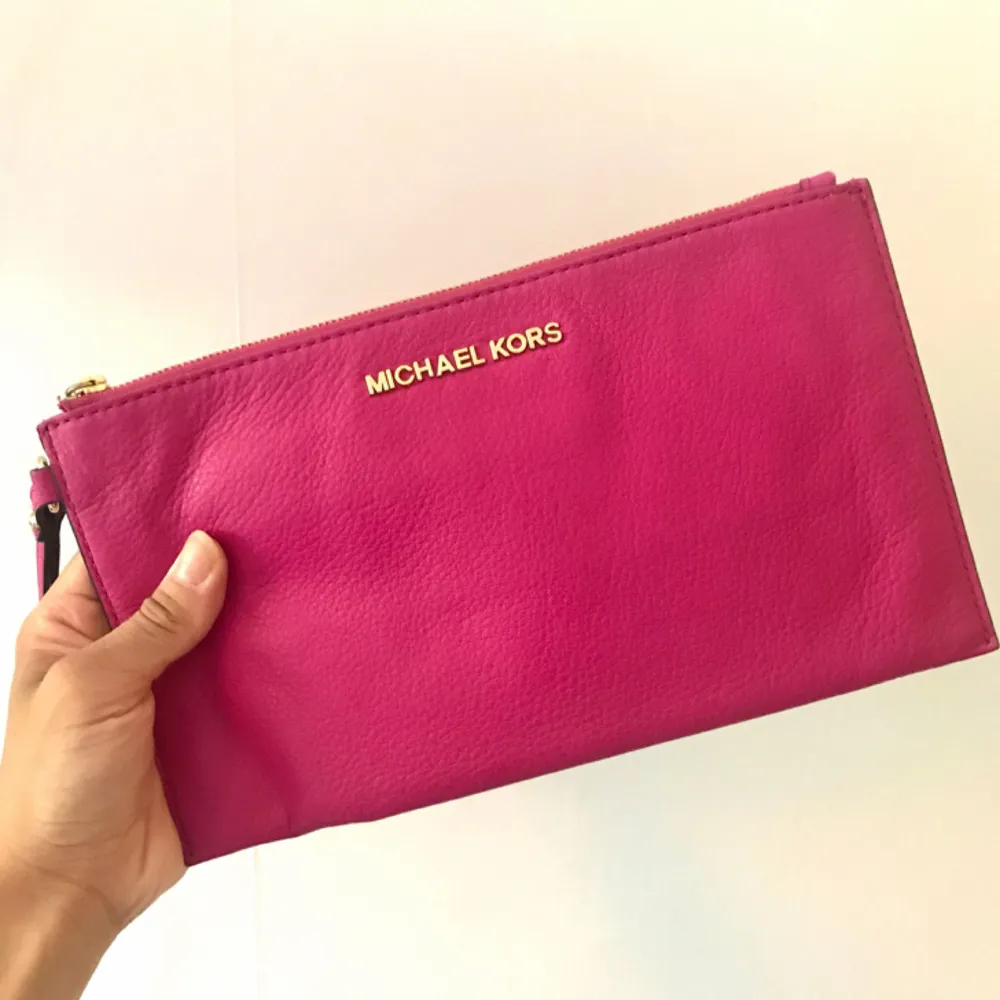 Äkta kuvertväska i cerise rosa från Michael Kors, köpt i New York för några år sen och har tyvärr inte kvittot kvar.   Massa innefack och sparsamt använd.  Mini fläck på baksidan från en bläckpenna. . Väskor.