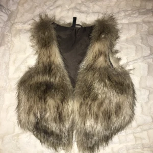 - Suuuuper snygg pälsväst i en spräcklig brun färg. Den är väldigt fin att ha över en jacka eller bara en tröja. Passar både XXS och S  vilket är en fördel :)