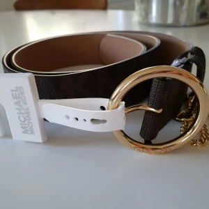  - Michael Kors bälte. Mått 110 cm lång, 4cm bred. Dvs storlek L.  Givetvis original, inköpt på Michael Kors butik i USA.  Gratis leverans i Söderort. 