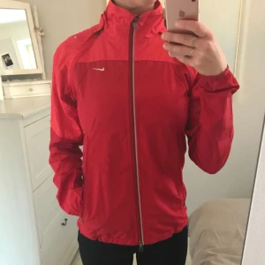  - Röd vindjacka från Nike, endast använd en gång. Mycket bra skick och superfin färg! 