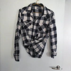  - Rutig skjorta i svart, grått och vitt från Poco Loco Carlings. Två bröstfickor. Gratis frakt!