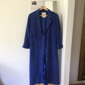En fin blå kappa från monki, perfekt för vår/sommar. Är använd men i fint skick!
