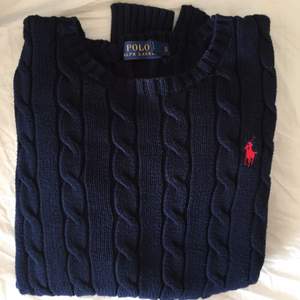 Mörkblå kabelstickad Ralph Lauren tröja i storlek xs. Den är något nopprig (se bild 2) 