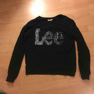  - Tröja från Lee, köpt på JC för 699 kr. Storlek S, passar XS med. Sparsamt använd. Paljetterna skiftar färg när man ”vänder” på dom mellan svart å mörkare silver. Mitt pris 100 + ev frakt.