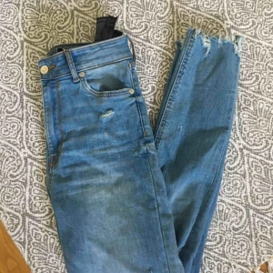  - Jeans från zara, högmidjade. Strechigt tyg. Storlek 36, slitningar både nedtill och på knäna. Fraktar endast, den är inräknad i priset!