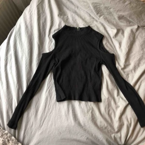  - Svart långärmad tröja med hål på axlarna. Dragkedja på baksidan! Använd max 3 gånger. Pris: 25kr+frakt