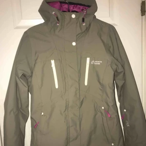  - Skidjacka som är använd en vinter. Storlek 36. Finns lite defekter såsom att färg har lossnat från dem vita knapparna och små fläckar som nog går bort i tvätten. Jackan är i en mörkgrön färg med rosa detaljer, och rosa inuti.  350 + frakt 