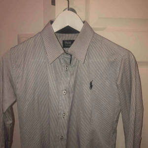  - Ralph Lauren skjorta som är vit/blå randig. Storlek M men enligt mig så är den som en S.  Kan mötas upp i Stockholm, köpare står för frakt och tar endast swish. Hör av dig för mer info.