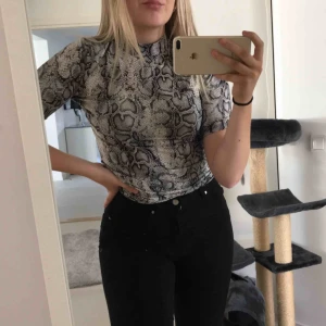  - T-shirt med en liten polokrage i ormskinns mönster. Priset är inkl frakt!