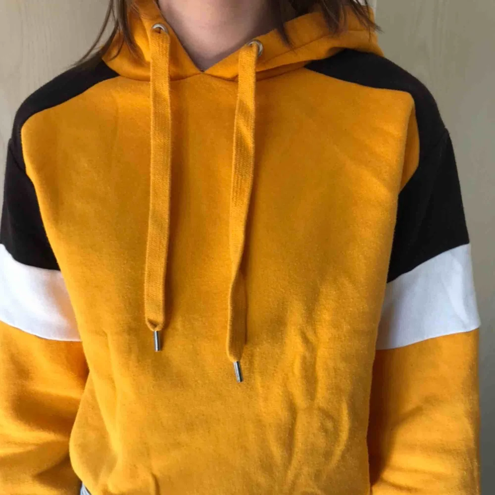 Cool gul hoodie med svarta och vita detaljer. Använd några gånger och supermysig!. Hoodies.