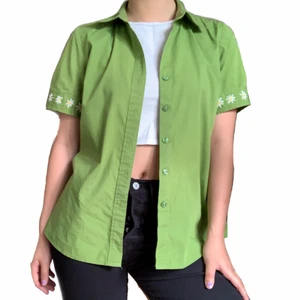 GRÖN SKJORTA - Grön skjorta med handbroderade blommor.