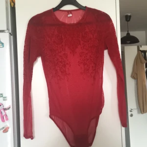 Rödbody stl s/m - Röd body med velor detaljer. Genomskinlig. 3 Knappar nertill. Använd 1 gång 