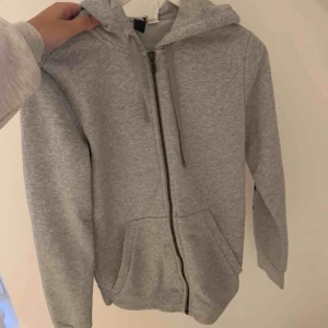 - Grå huvtröja med mörkblått adidas märke på ena armen och ett annat litet på baksidan. Väldigt fint skick och nästan aldrig använd! 