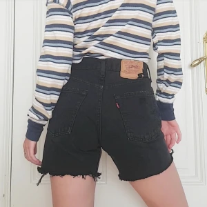 Vintage Levi's shorts - 🌿Finns kvar!🌿 Mörkblå/svarta vintage Levis shorts med hög midja som ger så fin booty ;) Fina slitningar och 4 synliga knappar i silver där fram! Säljer för att jag har ett par likadana :) Skriv om fler bilder önskas! 