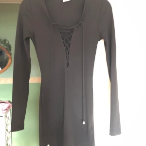 Klänning  - Svart klänning från Gina tricot med snörning vid brösten. Storlek xs, använd 1 gång