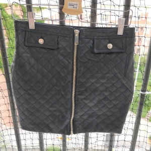 "skinn"kjol  - Fejkskinn med dragkedja fram. Fejkfickor och gulddetaljer. Möts helst upp annars tillkommer frakt! 