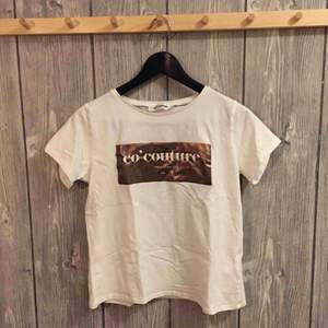 Vit t-shirt med mässing tryck från co’ couture i storleken S