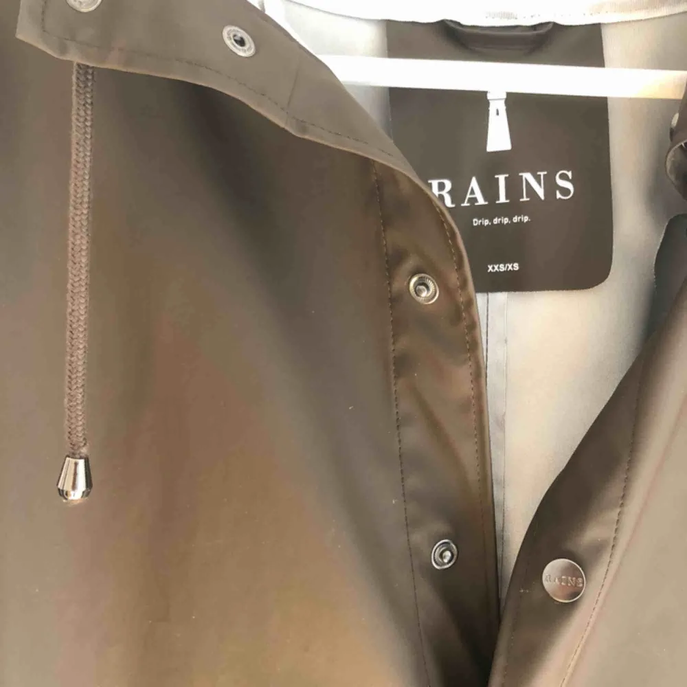 Mörkbrun regnjacka från märket RAINS. Endast använd ett fåtal gånger.  Nypris: 749kr. Jackor.