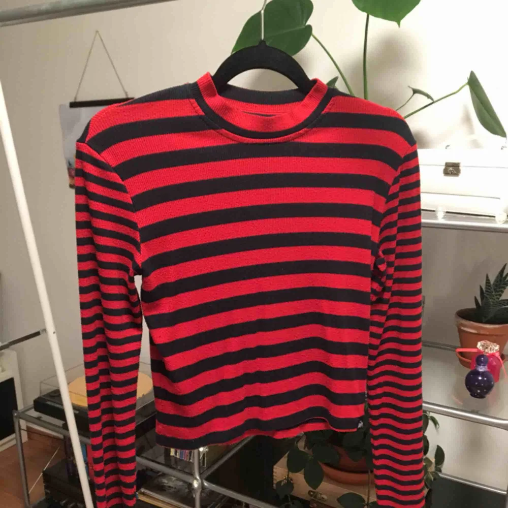 En långärmad tröja från Superdry. Lite räfflat tyg med svarta och röda ränder. Liten polokrage. Priset är inkluderat frakt.. Tröjor & Koftor.