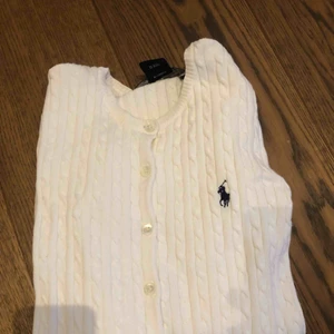  - Oanvänd Rahlf lauren kofta, mycket bra skick. Koftan är vit och det är en ficka på vardera sida om knapparna. 