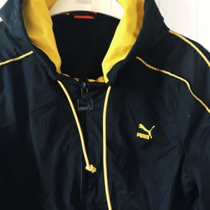  - Vindjacka från Puma. Gott skick, utom att ena snöret har gått av, men knappt märkbart. Frakt tillkommer