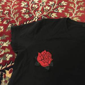 Svart t-shirt från bikbok med två snygga rosor på bröstet. (Varit såld markerar länge men inte fått pengarna, så den är tillbaka på hyllan.) :/ 