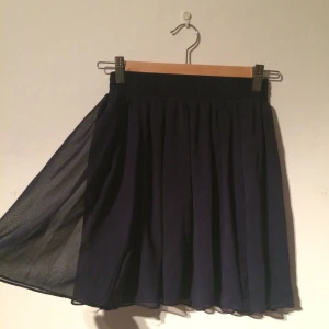  - Kort chiffonkjol från American Apparel i mörkblått. Bred resår i midjan. Använd endast ett fåtal gånger. Frakt tillkommer