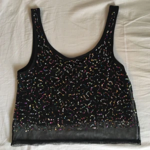  - Den perfekta fest toppen! Den är typ croppad (lite längre) och har ett svart tyg under och ett mesh tyg med paljetter över. Väl använd men som ny! Möts upp i Stockholm!:)