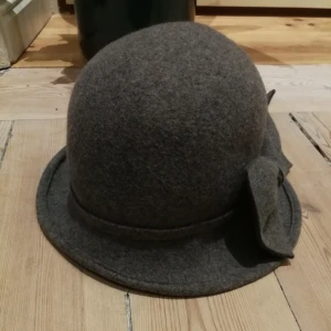  - Grå filthatt. Inköpt i Paris.  Har en rosett på sidan. 